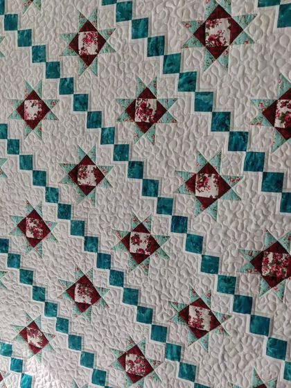 An angled view of the diagonal star quilt, showing the stippling quilting.