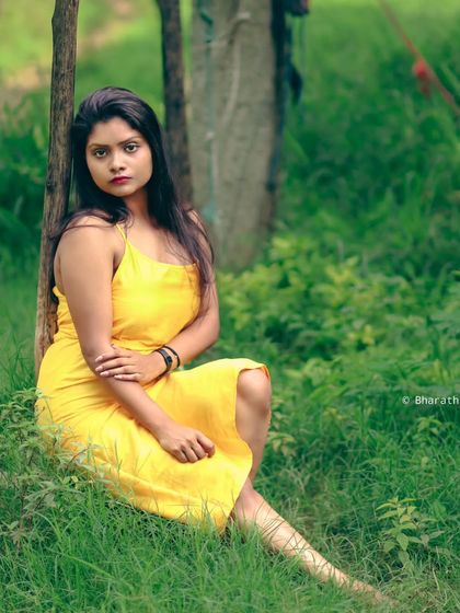 A classic seated portrait in a park. The composition is simple and timeless, focusing on the subject's relaxed pose.