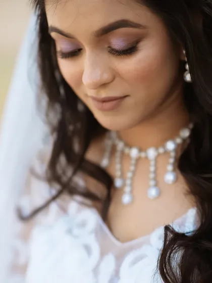 A close-up of the bride's eye makeup, featuring soft lavender and shimmer.