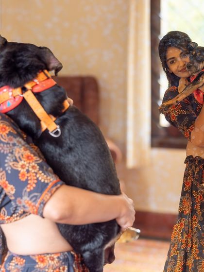 A soft, vintage-style photo capturing a woman holding her beloved indie dog. The reflection in the mirror adds a dreamy, artistic quality to the portrait.