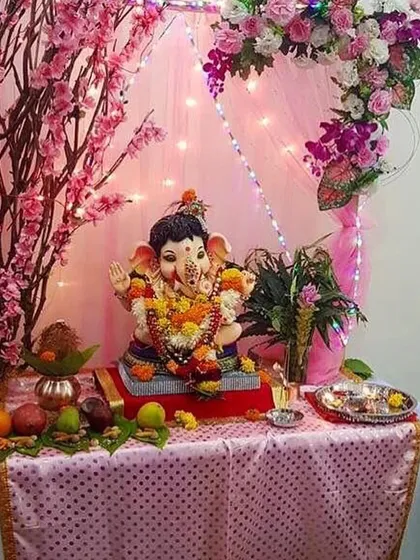 A sweet and simple decoration with pink drapes, fairy lights, and branches of cherry blossoms. It's a perfect, delicate setup for a small idol at home.