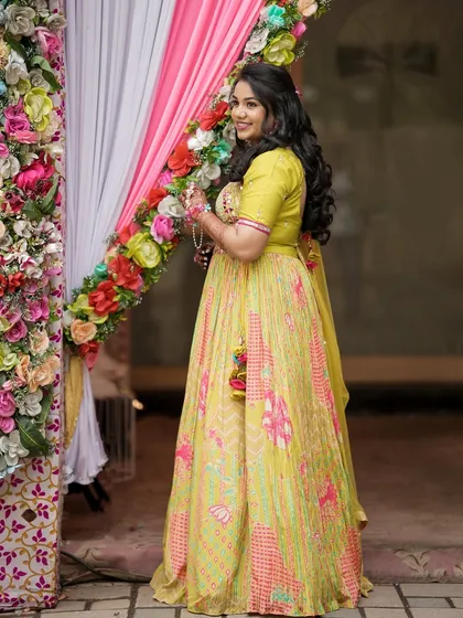A full-length shot of the Haldi bride, looking radiant in her yellow lehenga. The makeup is designed to complement the vibrant colors of the ceremony.