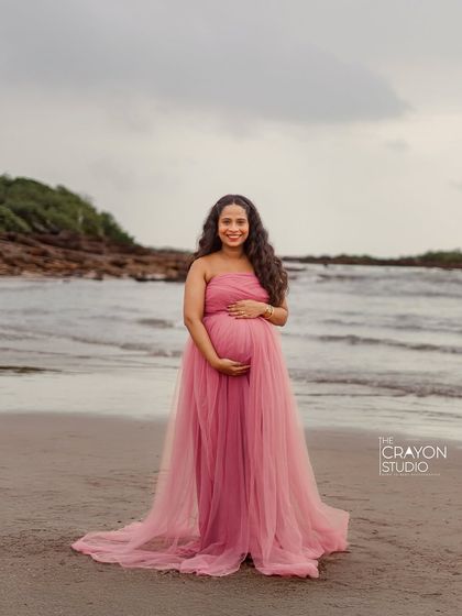 Standing on the beach in a flowing pink gown, she radiates joy and confidence. This portrait showcases how a beautiful dress can add a touch of magic to an outdoor shoot.