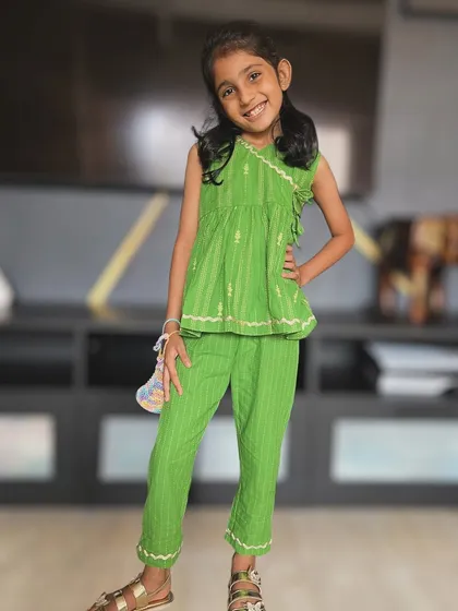 Our little muse is shining bright in this green ruffle-trim top and pant set. It's made from the softest cotton to keep her feeling light and breezy all day.