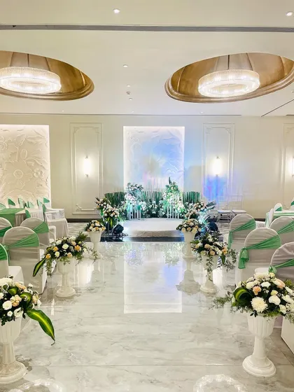 An elegant engagement setup in a pristine white banquet hall. I used minimal greenery and white floral arrangements to complement the venue's architecture, creating a fresh and sophisticated look.