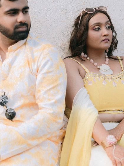 A quiet, candid portrait of Nikita and Harsh. The soft colors and their thoughtful expressions create a moment of calm intimacy amidst the vibrant Haldi celebrations.