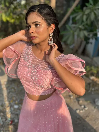 The full look, with the model looking confident and beautiful. The pink tones in the makeup and outfit are perfectly coordinated.