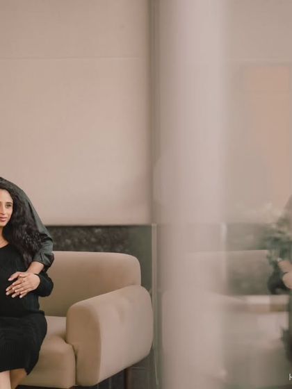 A moody and artistic indoor maternity portrait. The reflection in the glass adds a layer of depth and thoughtfulness to this intimate moment.