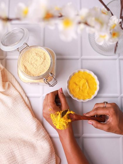 A DIY ubtan recipe in action. This shot shows the texture of the paste being applied to the skin, which is a great way to make the product feel relatable and effective.