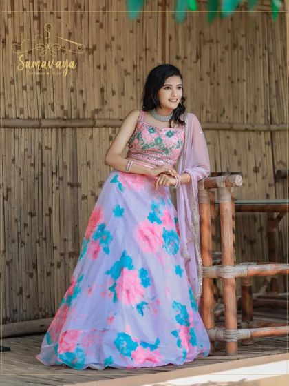 This full-length shot shows how a traditional lehenga can be styled for a contemporary outdoor photoshoot. The bamboo background adds a unique texture.