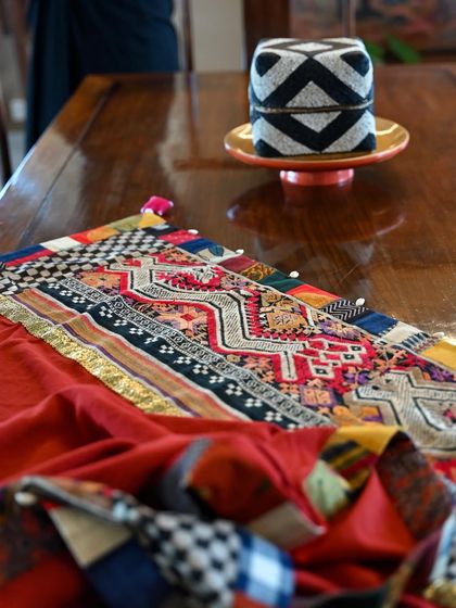 A soft-focus shot that highlights the texture and craftsmanship of the wrap's patchwork border, a testament to the stories collected from my travels around the world.