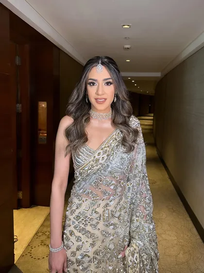 A three-quarter view that captures the shimmer of the saree and the soft, glamorous makeup.