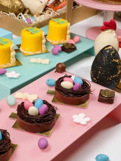 An assortment of festive, Easter-themed desserts, including chocolate nests and mini cakes, from a gourmet baker.