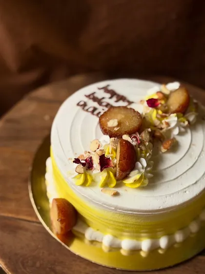 A closer look at the Gulabjamun Rabdi cake, showing the juicy gulab jamuns and chopped nuts.