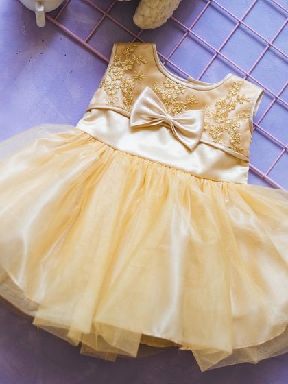 This golden-yellow gown is perfect for a summer celebration. The embroidered bodice and layered tulle skirt create a light and airy look that seems to glow.