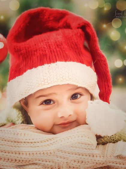 A close-up portrait of a baby during their first holiday season. The soft lighting and cozy textures create a warm and dreamy atmosphere for this newborn photo.