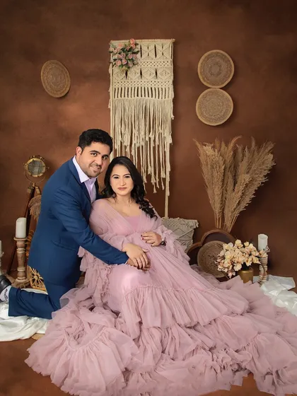 A regal and loving portrait of the expecting couple. The mom-to-be looks radiant in a ruffled pink gown, perfectly complemented by the earthy tones of our boho set.