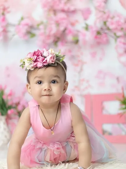 A crawling pose amidst the flowers. This shows a different angle of the beautiful, immersive pink floral setup.