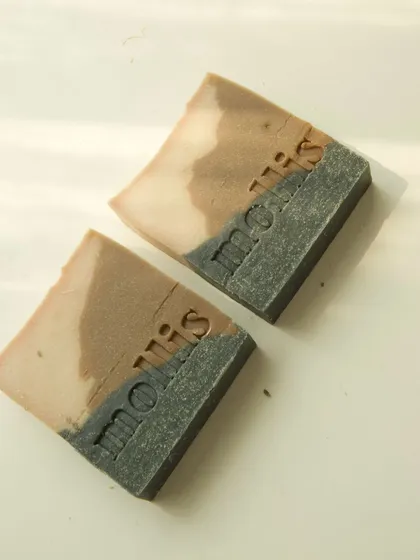 A duo of layered charcoal and clay soaps.