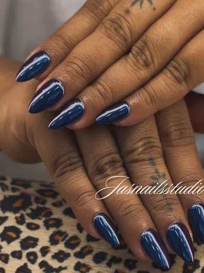 A deep, metallic blue chrome polish on a sharp almond shape. This look is bold, confident, and incredibly chic.