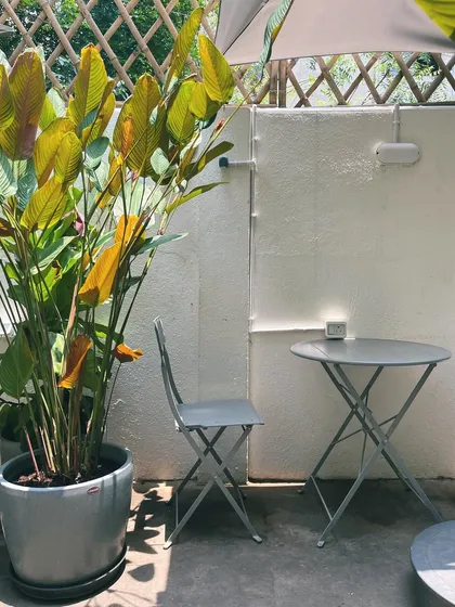 A quiet corner in our garden, waiting for you. This simple setup is perfect for a solo coffee or a one-on-one chat.