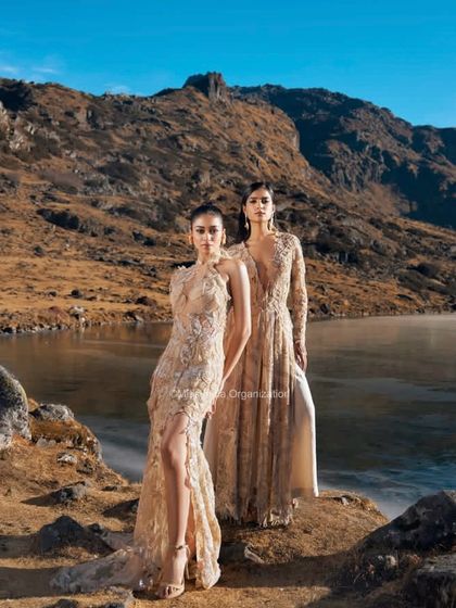 An editorial look featuring two models by a lake. Their hairstyles are elegant and polished, designed to withstand the outdoor elements while looking flawless on camera.