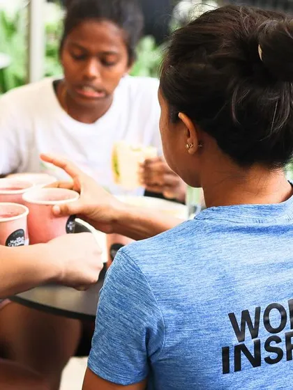 A candid shot of athletes being served refreshments. We ensure every aspect of the athlete's experience, including nutrition and rest, is taken care of during our camps.