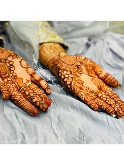 The front view of the guest's mehendi, showing a different, more intricate pattern on the palms.