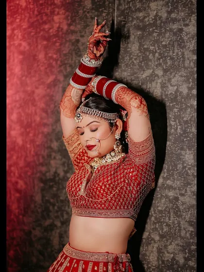 A dramatic and artistic shot of me on my wedding day, captured in a "lal ishq" theme. The red lehenga, the pose, and the lighting all come together beautifully.