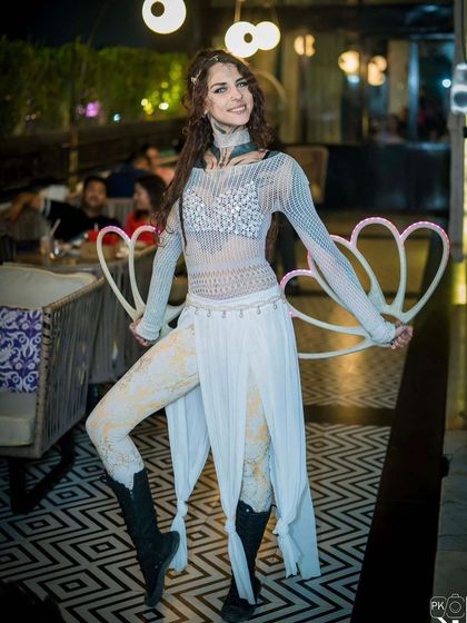 A solo female performer in an elegant white costume holds her LED fans. This act is versatile and can fit a variety of themes, from winter wonderland to a white party.