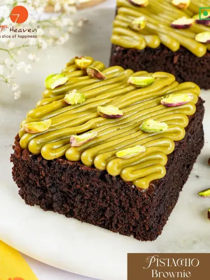 A rich and fudgy Pistachio Brownie. This dessert features a dense chocolate brownie base with a creamy pistachio frosting and a sprinkle of chopped pistachios.