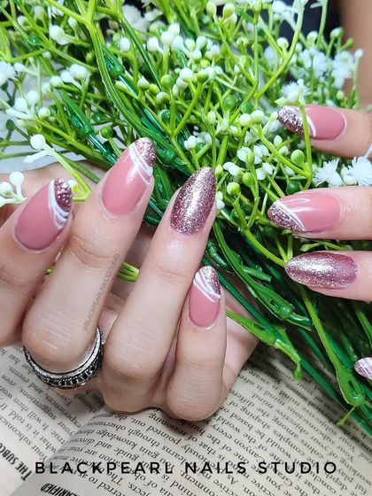 An elegant design featuring nude polish with glitter accent nails and delicate white spider gel lines. This is a chic and sophisticated way to combine different textures and effects.