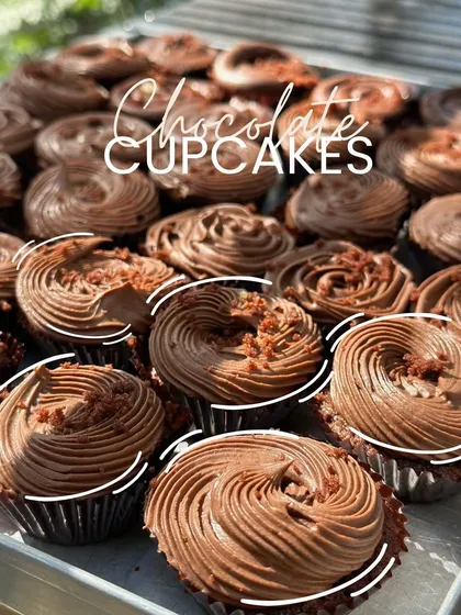 A tray of my classic, rich chocolate cupcakes. Each one is 100% eggless and topped with a generous swirl of luscious chocolate cream and a sprinkle of chocolate shavings.