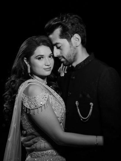 A classic black and white portrait of a couple at their reception, their pose exuding elegance and timeless romance.