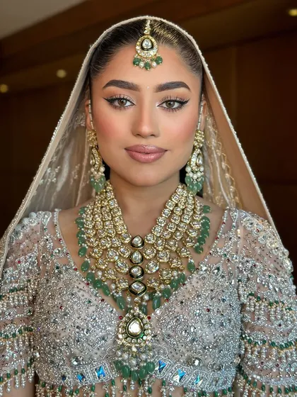 A stunning close up of Tanvi's bridal look. The focus is on my signature winged liner, flawless skin, and the magnificent polki and emerald jewelry.