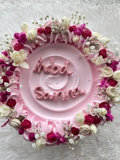 A top-down view of the tall floral cake, showing the intricate arrangement of tiny flowers and piped details.