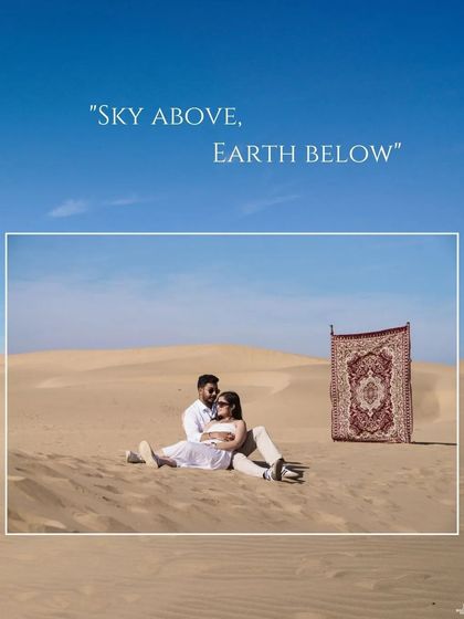A serene shot of the couple relaxing on the desert sand with a "magic carpet" prop, framed by the text "Sky above, Earth below."