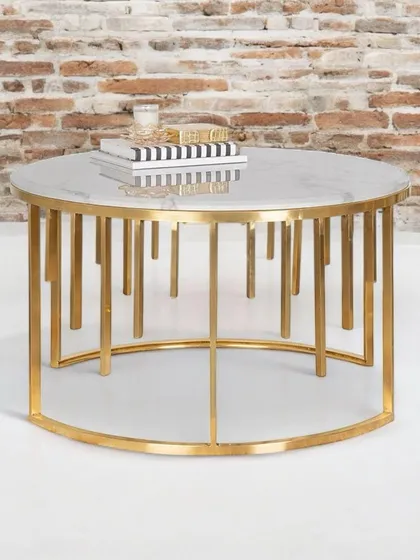 The Golden Quasar coffee table features an intricate cage-like base made from stainless steel, topped with a classic white marble surface. This piece blends modern design with timeless luxury, creating a stunning centerpiece.