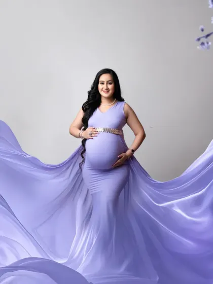 A classic maternity portrait with a beautiful lavender gown. The flowing fabric creates a sense of grace and elegance, perfect for celebrating this special time.