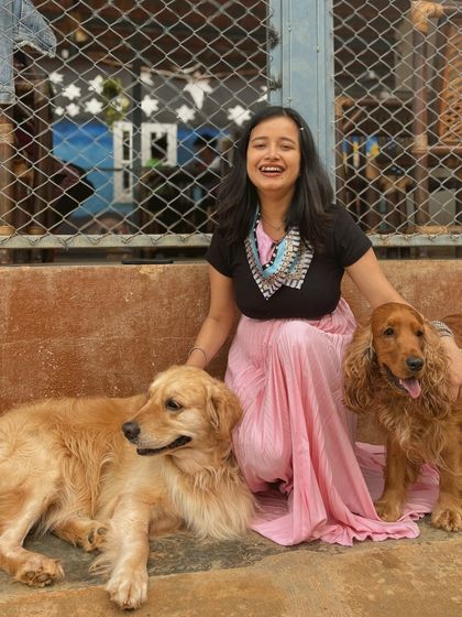 A happy guest poses with a Golden Retriever and a Cocker Spaniel, enjoying the company of our dogs.