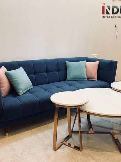 Another view of the comfortable and stylish navy blue sofa, adorned with pastel-colored cushions that add a soft, welcoming touch.