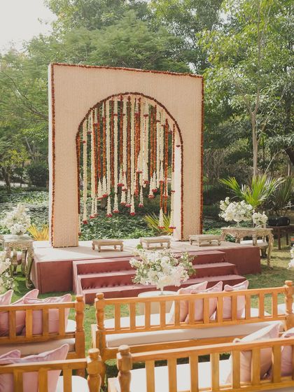 A simple yet elegant seating area on the lawn, with a beautiful backdrop of hanging flowers.
