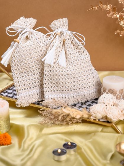 Another view of our elegant jute potlis, presented on a checkered tray with festive candles. These are perfect for filling with small treats and make for wonderful, eco-friendly Diwali return gifts.