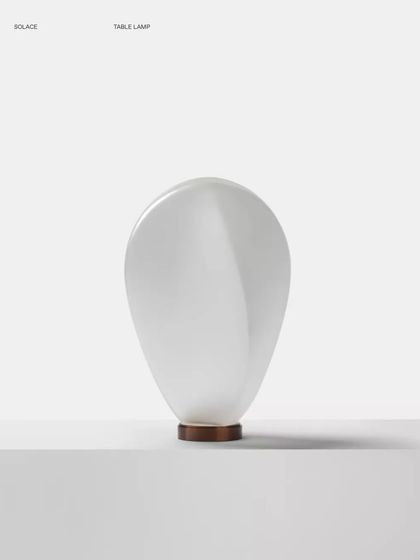 A studio shot of the white glass Solace lamp against a clean white background, emphasizing its pure, minimalist form.