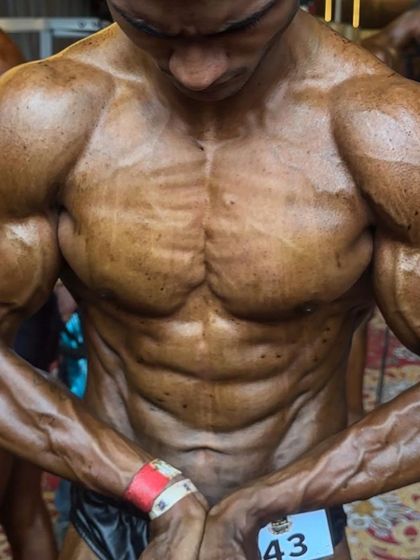 A close-up of an abdominal and thigh pose backstage. The detail and dryness are the result of a perfectly executed peak week and posing practice.