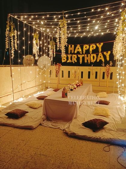 The central table is set for dinner, surrounded by cushions, creating a warm and inviting space for guests to gather and celebrate.