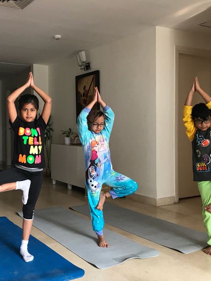 Finding their balance in Tree Pose (Vrikshasana). I guide children through classic yoga poses in a way that feels like a game, helping them develop focus and stability.