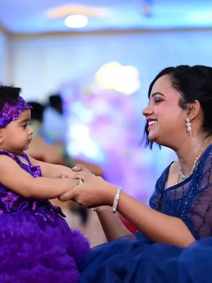 Capturing a beautiful moment between a mother and daughter. The daughter wears a custom vibrant purple party dress with voluminous ruffles, designed for celebration. I pride myself on creating outfits that bring joy and receive wonderful feedback on fit and timely delivery.