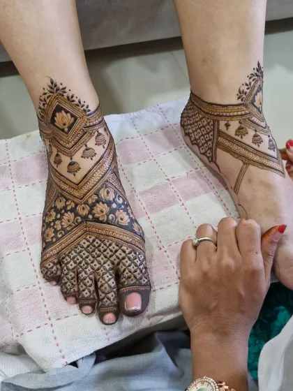 Foot mehendi requires a different approach to design and application. Here, you can see a complete bridal foot design featuring geometric patterns, floral details, and traditional jhumka motifs.