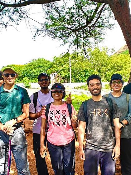 A group of trekkers under a tree, ready for their hike. This shows the start of another great adventure with a new group of friends.